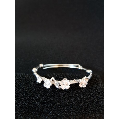 Sterling silver bangle with flowers and branches.